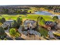 Expansive estate on a golf course, with a circular driveway and lush landscaping, near a frozen lake at 73 Glenmoor Dr, Cherry Hills Village, CO 80113