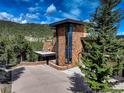 Beautiful stone home with black trim, mountain views, and a large driveway at 180 Outpost Ln, Evergreen, CO 80439