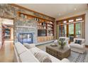 Inviting living room features a stone fireplace, built-in shelving, and sliding doors to the outdoors at 180 Outpost Ln, Evergreen, CO 80439