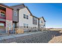 Eye-level view of charming townhomes with a fenced yard and modern color scheme at 2839 E 103Rd Dr, Thornton, CO 80229