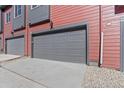 Two car garage door painted gray with a matching gray trim and red siding above at 2839 E 103Rd Dr, Thornton, CO 80229