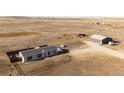 Aerial view of a property featuring a cozy home, a detached garage, and lots of land at 6201 S Vanderhoof St, Bennett, CO 80102