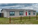 Inviting exterior showcasing a cozy home with a red front door and a rustic wooden fence at 6201 S Vanderhoof St, Bennett, CO 80102