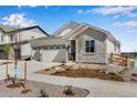 Charming single Gathering home featuring a three car garage, stone accents, and drought resistant landscaping at 24593 E 34Th Ave, Aurora, CO 80019