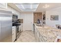 Galley kitchen featuring granite countertops, white cabinetry, and stainless steel appliances at 23694 Pondview Pl # B, Golden, CO 80401