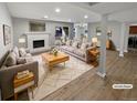 Bright, staged living room featuring a painted brick fireplace, wood floors, and access to the backyard at 7251 S Xenia Cir # B, Centennial, CO 80112