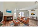 Bright living room with vaulted ceilings, fireplace, and sliding glass doors leading to patio at 8898 W Plymouth Ave, Littleton, CO 80128