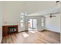 Airy living room with a fireplace, light wood floors, and sliding glass doors to outdoor space at 8898 W Plymouth Ave, Littleton, CO 80128