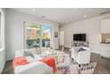 Bright and airy living room featuring hardwood floors, a modern sofa, and a balcony with outdoor seating at 1300 N Ogden St # 204, Denver, CO 80218