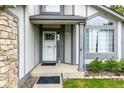 Inviting front entrance with decorative trim, a stone accent wall, and well-maintained landscaping at 8918 W 101St Ave, Broomfield, CO 80021