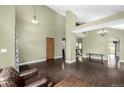 Open-concept living room with hardwood floors, high ceilings, and stylish light fixtures at 8918 W 101St Ave, Broomfield, CO 80021