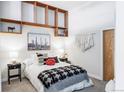 Bright bedroom with overhead shelving, stylish bedding, and black bedside tables at 7700 E 29Th Ave # 411, Denver, CO 80238