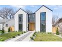 Modern two-story home with light exterior, black trim, rock pathway, and minimalist landscaping at 3047 S Cherokee St, Englewood, CO 80110