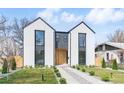 Modern two-story home with light exterior, black trim, rock pathway, and minimalist landscaping at 3047 S Cherokee St, Englewood, CO 80110