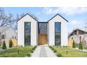 Modern two-story home with light exterior, black trim, rock pathway, and minimalist landscaping at 3047 S Cherokee St, Englewood, CO 80110