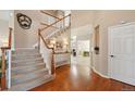 Elegant entryway with hardwood floors, a staircase with white railings, and abundant natural light creating a warm and inviting space at 10572 Jaguar Gln, Lone Tree, CO 80124