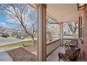 Inviting front porch with comfortable wicker furniture, perfect for enjoying the neighborhood views and the shade of mature trees at 10572 Jaguar Gln, Lone Tree, CO 80124