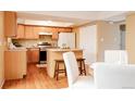 Cozy kitchen with light wood cabinets, island, and adjacent dining area at 654 S Xenon Ct, Lakewood, CO 80228