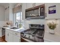 Modern kitchen features white cabinets, stainless steel appliances, and herringbone backsplash at 1193 Highview Ln, Erie, CO 80516