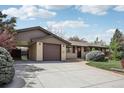Home with a driveway, attached garage, and car port, blending functionality with traditional design elements at 1164 W 101St Pl, Northglenn, CO 80260