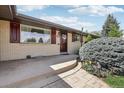 Inviting entrance featuring a brick facade, well-manicured shrubbery, and a step-up pathway, creating a welcoming approach at 1164 W 101St Pl, Northglenn, CO 80260