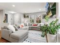 Bright living room with a large sectional couch, modern decor, and plenty of natural light at 2184 Willow Ct, Denver, CO 80238