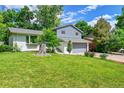 Landscaped front yard with mature trees and a well-maintained lawn around the house at 6368 S Harlan Way, Littleton, CO 80123