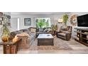 Cozy living room with a comfortable sectional sofa, a leather armchair, and light-toned laminate flooring at 6368 S Harlan Way, Littleton, CO 80123