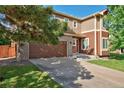 A two-story home with a brick-accented garage, complemented by lush greenery and a well-maintained lawn at 3355 Willowrun Dr, Castle Rock, CO 80109