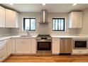 Bright kitchen featuring stainless steel appliances, white cabinets, and quartz countertops at 2895 Poplar St, Denver, CO 80207