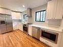 Modern kitchen boasts stainless steel appliances, white cabinets, and quartz countertops at 2895 Poplar St, Denver, CO 80207