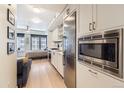 Bright, modern kitchen with stainless steel appliances and adjacent bedroom with a view at 1750 Wewatta St # 805, Denver, CO 80202