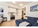 This stylish living room with stainless appliances is adjoined by a cozy space with a blue couch and a large ottoman at 1750 Wewatta St # 805, Denver, CO 80202