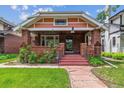 Inviting home exterior showcasing a brick facade, cozy front porch, and manicured landscaping at 869 S Williams St, Denver, CO 80209