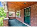 View of the brick porch with brick pillar features, a green screen door and a wooden ceiling at 869 S Williams St, Denver, CO 80209