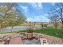 Landscaped backyard with pond and view of the water, the golf course, and neighborhood at 6802 Poppy Ct, Arvada, CO 80007