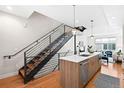 Open kitchen with white counters, stainless appliances, a wood island, and a staircase at 1836 Grove St # 105, Denver, CO 80204