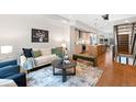 Bright living room with modern decor, open to kitchen and staircase at 1836 Grove St # 105, Denver, CO 80204