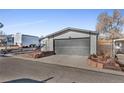 Home exterior showcasing a gray garage and landscaping at 2017 Tulane St, Denver, CO 80260