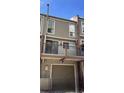 Two-story home exterior featuring a balcony, garage, brick chimney and modern siding at 805 E 7Th Ave # 8, Denver, CO 80218