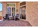 Brick front porch with seating and a welcoming entryway at 3481 Meadow Creek Pl, Highlands Ranch, CO 80126