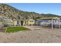 Quaint yellow home exterior with a convenient carport and low-maintenance gravel yard at 230 Miner St, Idaho Springs, CO 80452