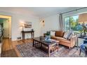 Bright living room with a cozy sofa, hardwood floors, an antique table, and natural light at 1235 Dahlia St, Denver, CO 80220