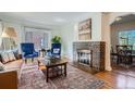 Elegant living room showcasing a brick fireplace, hardwood floors, a decorative rug, and refined decor at 1235 Dahlia St, Denver, CO 80220