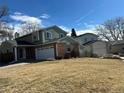 Traditional home featuring an attached two-car garage and professionally landscaped front yard at 5612 S Lansing Ct, Englewood, CO 80111