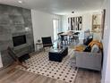 Open-concept living room with modern fireplace, stylish decor, and seamless access to the dining area at 5612 S Lansing Ct, Englewood, CO 80111