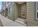 Inviting front entrance featuring a modern door with glass panels, neutral siding, and potted flowers at 1921 Hooker St, Denver, CO 80204