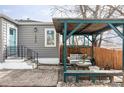 Cozy outdoor seating area with pergola, bench, and table with gray couch cushions at 2030 Cody St, Lakewood, CO 80215