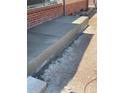 New concrete walkway along brick home provides a clean aesthetic at 1445 S Eaton St, Lakewood, CO 80232