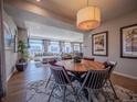 An inviting dining area featuring a round table, stylish chairs, and a modern light fixture, flowing into the living space at 17548 E 103Rd Dr, Commerce City, CO 80022